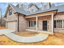 Charming brick home featuring a two-car garage, covered porch, and classic black shutters at 5230 Club View Dr, Concord, NC 28025