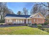 Charming single-story home with a welcoming front porch and a mix of brick and siding exterior at 7135 Folger Dr, Charlotte, NC 28270