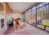 Inviting screened porch with rocking chairs offers a relaxing view of the wooded backyard at 8115 Kingsland Dr, Waxhaw, NC 28173