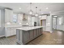 Bright kitchen with a large gray island, white cabinetry, stainless steel appliances, and pendant lighting at 9657 Liberty Hill Dr, Mint Hill, NC 28227