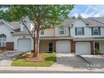 Brick townhouse exterior with attached garage and landscaping at 10841 Twisted Bark Ln, Charlotte, NC 28213