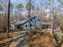 Gray house with a large covered porch and wooded surroundings at 11270 Widenhouse Rd, Midland, NC 28107