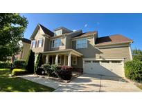 Attractive two-story home features a two-car garage, manicured landscaping, and a covered front porch at 11519 Sweet Birch Ln, Charlotte, NC 28278