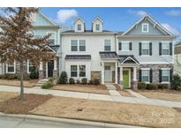 Three-story townhome with gray and white siding, a green door, and stone accents at 12515 Bryton Ridge Pkwy, Huntersville, NC 28078