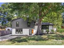 Stunning ranch home with gray and white exterior, landscaping, and large tree at 3801 Woodleaf Rd, Charlotte, NC 28205