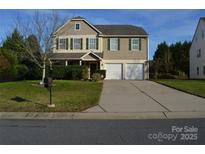 Charming two-story home with a well-manicured lawn and a two-car garage at 5012 Brodie Ln, Fort Mill, SC 29707