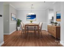 Bright dining room featuring wood floors, modern light fixture and stylish furnishing at 5617 Fairview Rd # 9, Charlotte, NC 28209