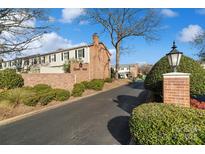 Brick townhouses with landscaping, entrance, and a sign that says Quail Hill at 5915 Quail Hollow Rd # E, Charlotte, NC 28210