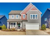 Two-story house with gray siding, red accents, and a two-car garage at 6265 Six String Ct, Fort Mill, SC 29708