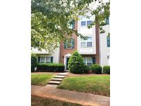 Three-story townhome with green landscaping and a charming front entrance at 6808 Cascade Dream Ct # 118, Huntersville, NC 28078