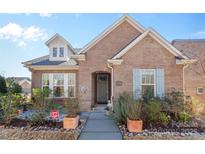 Brick ranch home with gray door, landscaping, and walkway at 703 Marion Dr, Matthews, NC 28105