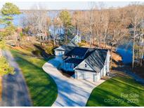 Lakefront home with circular driveway and detached garage, offering serene waterfront views at 7476 Point St, Denver, NC 28037