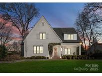 Charming brick home featuring manicured landscaping, wooden door, and a welcoming covered front porch at 1108 Ardsley Rd, Charlotte, NC 28207