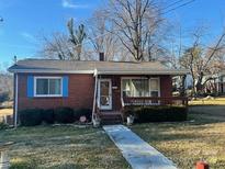 Brick ranch house with a porch, steps, and a landscaped yard at 2327 Catalina Ave, Charlotte, NC 28206