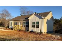 Exterior view of a well-maintained home featuring a side entrance and neatly landscaped front yard at 819 Wellwood Ave, Statesville, NC 28677