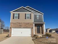 Two-story brick home with a white garage door and landscaping at 141 Hayes Rd, Kings Mountain, NC 28086