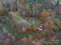 Aerial view of the home nestled amongst the fall foliage with a long drive and a small pond at 2073 Mauney Rd, Bessemer City, NC 28016