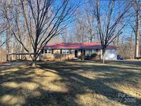 Ranch style home with red metal roof, carport, and spacious yard at 303 Dana Dr, Salisbury, NC 28147