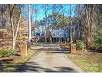 Brick house with a large front porch and driveway, surrounded by trees at 3788 Panthers Den Ct, Concord, NC 28027