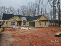 New construction home featuring yellow siding, black roof, and attached two-car garage at 609 Shiloh Unity Rd, Lancaster, SC 29720