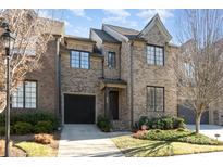 Charming brick townhome features a well-maintained lawn, attached garage and classic architectural details at 6411 Aldworth Ln, Charlotte, NC 28226