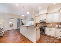 Bright kitchen featuring granite countertops, stainless steel appliances, and an island with bar seating at 6411 Aldworth Ln, Charlotte, NC 28226