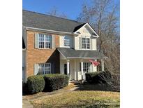 Two-story house with brick and vinyl siding, covered porch, and landscaped yard at 1941 Olsen Ln, Charlotte, NC 28213