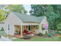 Charming single-story home featuring a cozy front porch with red cushioned chairs and landscaped yard at 2407 Brookside Ave, Kannapolis, NC 28081