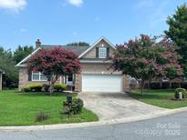 Brick ranch home with attached garage and landscaped yard at 2509 Calgary Pl, Concord, NC 28027