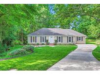 Charming home featuring a lush green lawn, complemented by mature trees and a well-maintained landscape at 4145 Wall St, Charlotte, NC 28209