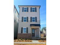 Charming three-story home with gray siding, brick accents, dark shutters, and inviting front entrance at 429 Delburg Mill Alley Dr, Davidson, NC 28036