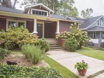 Charming red bungalow with landscaped front yard and walkway at 523 W 2Nd Ave, Gastonia, NC 28052