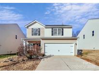 Two-story house with a white garage door and landscaping at 6908 Agava Ln, Charlotte, NC 28215