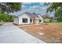 Newly constructed home with white siding, dark windows, and a concrete driveway at Lot 1 Sloop St, China Grove, NC 28023