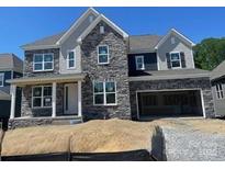 New construction home featuring stone veneer, an attached two-car garage, and a welcoming front porch at 147 Holsworthy Dr, Mooresville, NC 28115