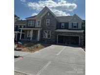 New two-story home with stone and siding, an attached garage, and a concrete driveway at 147 Holsworthy Dr, Mooresville, NC 28115