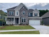 Charming two-story home featuring a stone facade, covered porch, and two-car garage at 147 Holsworthy Dr, Mooresville, NC 28115