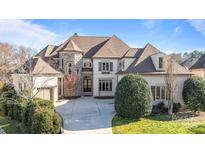 Elegant two-story home boasts stone accents, manicured landscaping, and a circular driveway at 7409 Stonecroft Park Dr, Charlotte, NC 28226