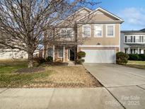 Two-story house with brick and beige siding, a two-car garage, and a well-maintained lawn at 1104 Less Traveled Trl, Indian Trail, NC 28079