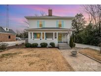 Charming two-story home with a welcoming front porch and cheerful blue shutters at 132 N Confederate Ave, Rock Hill, SC 29730