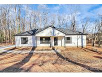 White house with black trim, covered porch, and a landscaped yard at 1851 Twin Lakes Rd, Rock Hill, SC 29732
