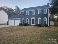 Two-story house featuring a gray exterior, two-car garage, and well-maintained lawn at 2701 Olde Whitehall Rd, Charlotte, NC 28273