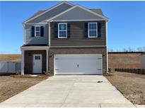 Charming two-story home featuring a brick and siding facade, a two-car garage, and a well-maintained lawn at 301 Brinkley Dr, Kings Mountain, NC 28086