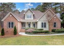 Charming brick and siding home with manicured lawn and beautiful landscaping at 302 Mccrary Rd, Mooresville, NC 28117