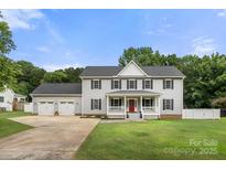 Charming two-story home features a welcoming front porch, three-car garage, and beautifully manicured lawn at 7545 Haley Ln, Indian Land, SC 29707