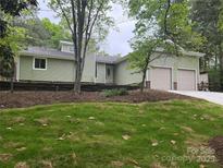 Charming home exterior with light green siding, a two-car garage, and a well-manicured lawn at 10912 Treebark Dr, Charlotte, NC 28226