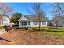 White house with gray roof, front porch, and landscaped yard at 210 Lauren Dr, Indian Trail, NC 28079