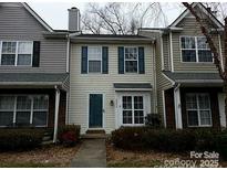 Two-story townhome with gray siding, green door, and landscaping at 2237 Cigar Ct, Charlotte, NC 28273