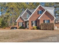 Brick house with stone accents, landscaped lawn, and a paved driveway at 305 Goldfinch Ct, Shelby, NC 28150