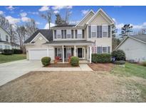 Two-story house with a covered porch, two-car garage, and manicured lawn at 3812 Leela Palace Way, Fort Mill, SC 29708